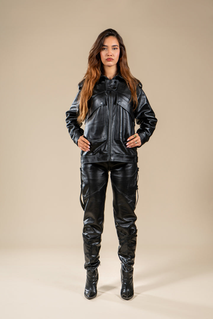 Pantalon Amnay Numidie en cuir noir, porté par un modèle, avec coupe ajustée et détails de poches latérales.