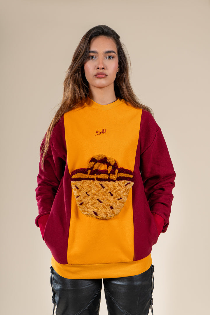 Pull Kouffa Numidie jaune et bordeaux avec motif tufting artisanal, porté par une femme.