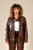 Veste Aviateur Azir en cuir marron portée par une femme, vue de face avec détails des poches.