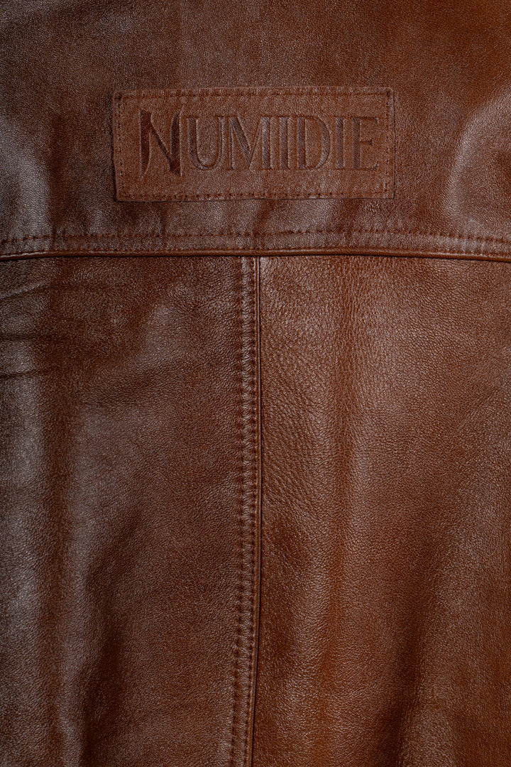Détail du marquage Numidie embossé sur le cuir marron de la robe Tihya.