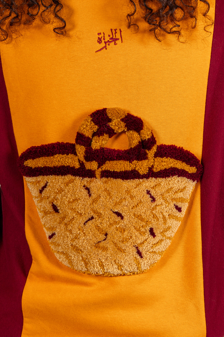 Détail du motif tufting artisanal du pull Kouffa Numidie jaune et bordeaux.