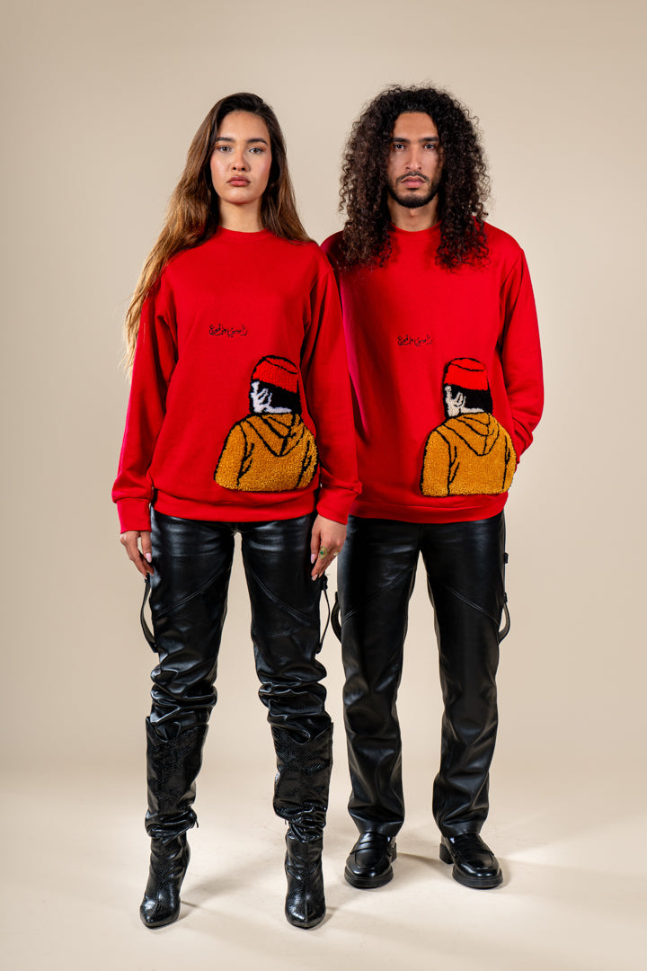 Pantalon Amnay Numidie en cuir noir, porté par deux modèles avec des pulls rouges, mettant en valeur sa coupe et ses détails.