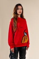 Pull Tarbouche Numidie rouge avec motif tufting artisanal, porté par une femme, vue de trois-quarts.