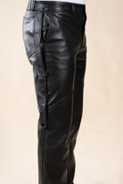 Pantalon Amnay Numidie en cuir noir, vue rapprochée des détails de coupe, des poches latérales et des sangles.
