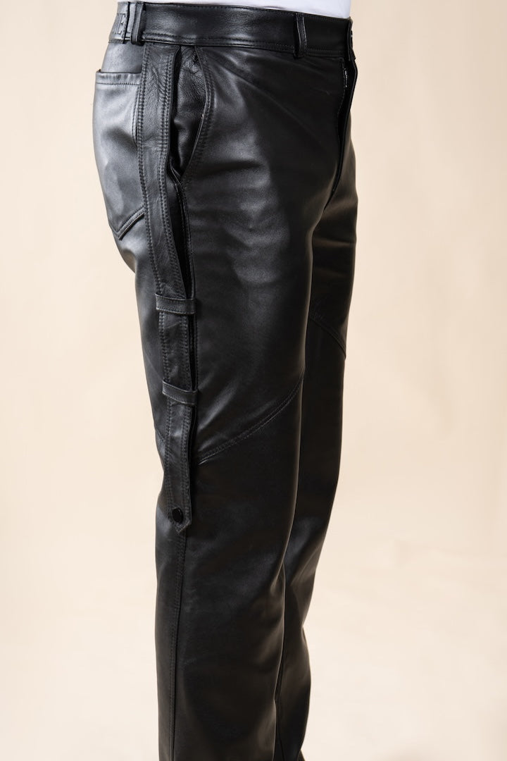 Pantalon Amnay Numidie en cuir noir, vue rapprochée des détails de coupe, des poches latérales et des sangles.